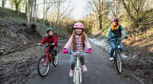 Woman and two children riding bikes in winter